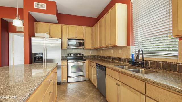 kitchen with backsplash, sink, stainless steel appliances, and light brown cabinetry