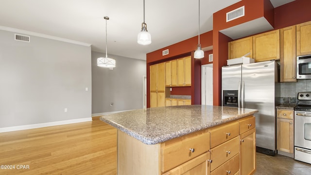 kitchen featuring stainless steel appliances, decorative light fixtures, decorative backsplash, a kitchen island, and light wood-type flooring