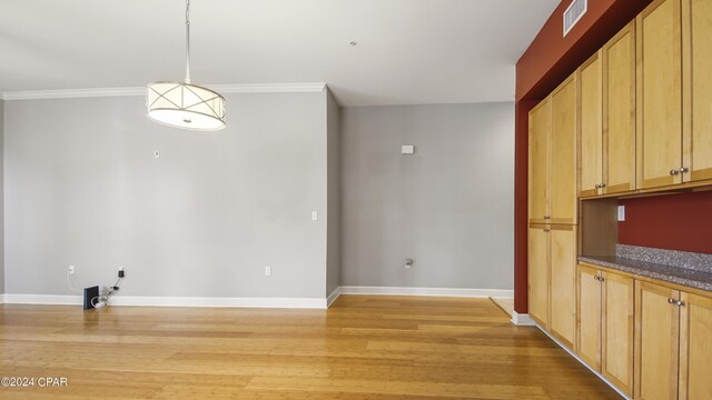 unfurnished dining area with crown molding and light hardwood / wood-style flooring