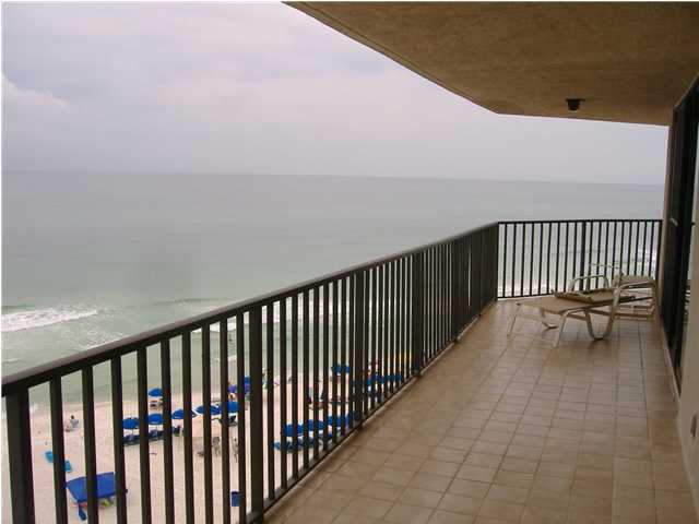 balcony with a water view and a view of the beach