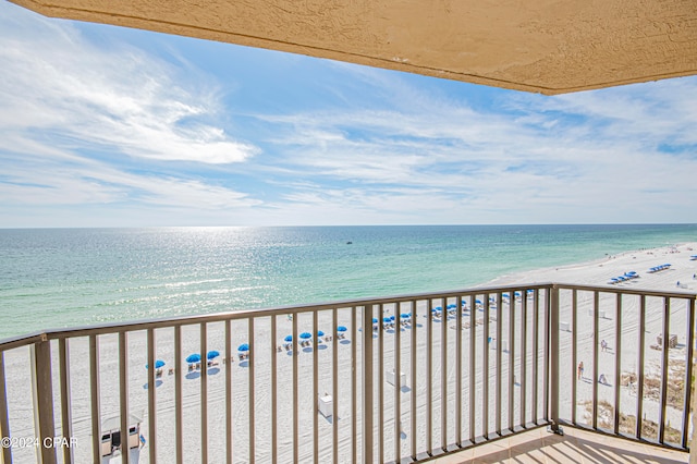 balcony featuring a water view and a beach view