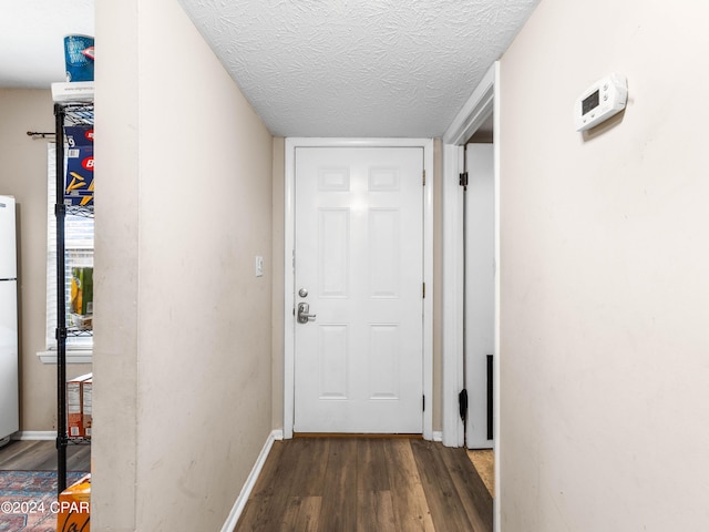 hallway with a textured ceiling and dark wood-type flooring