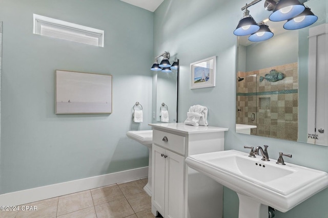 bathroom with tile patterned flooring, tiled shower, and sink