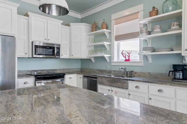 kitchen featuring white cabinetry, dark stone countertops, crown molding, and stainless steel appliances