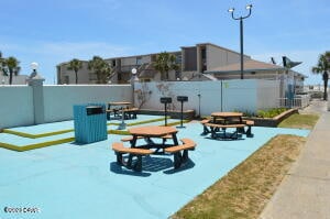 view of property's community with a patio and an outdoor fire pit