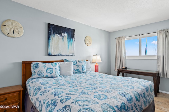 tiled bedroom featuring a textured ceiling