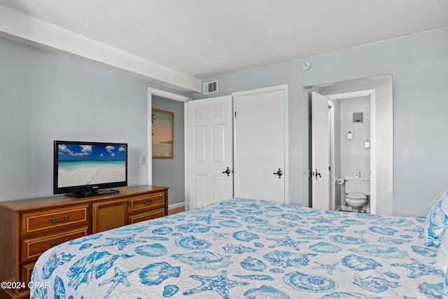 bedroom with ensuite bathroom and a textured ceiling