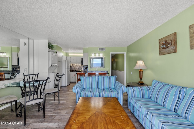 living room with a textured ceiling and hardwood / wood-style flooring