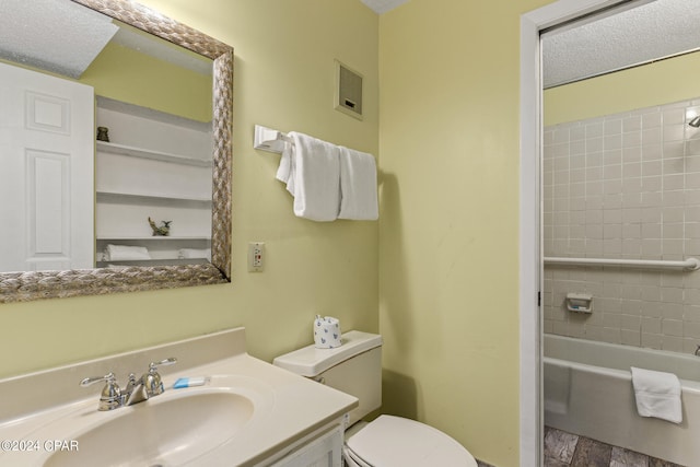 full bathroom with wood-type flooring, toilet, vanity, and a textured ceiling