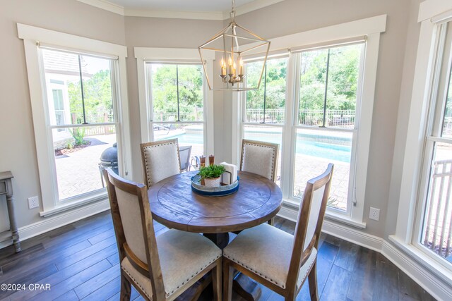 dining area featuring dark hardwood / wood-style flooring, a notable chandelier, and ornamental molding