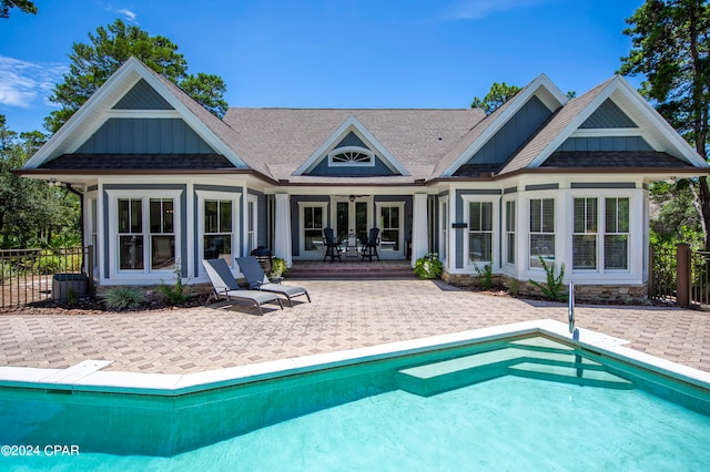 rear view of house featuring a fenced in pool and a patio area