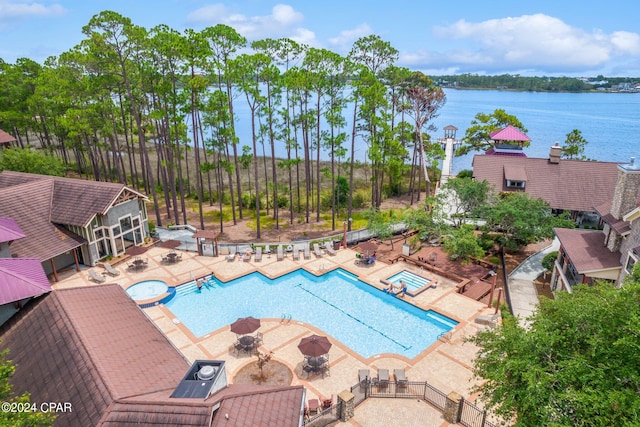 view of swimming pool featuring a patio and a water view