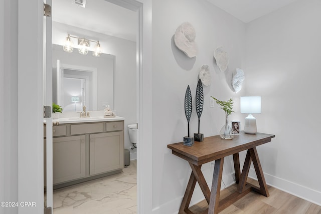 bathroom featuring hardwood / wood-style flooring, vanity, and toilet