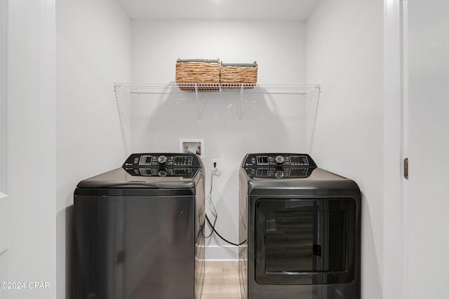 laundry room featuring hardwood / wood-style flooring and washer and dryer