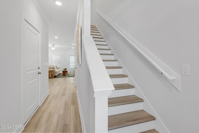 staircase with hardwood / wood-style flooring and ceiling fan