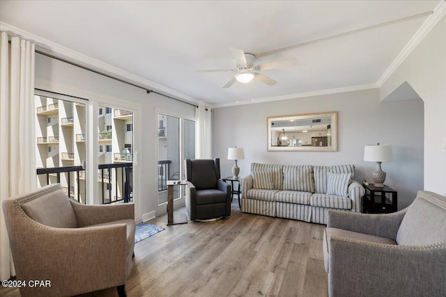 living room with ceiling fan, light wood-type flooring, and ornamental molding