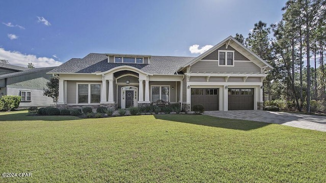 craftsman house featuring a garage, a front yard, and decorative driveway