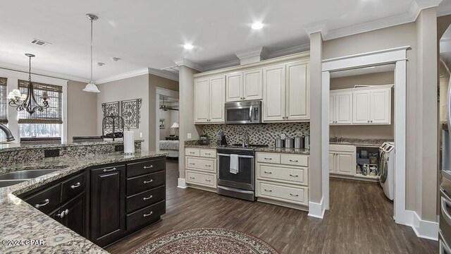 kitchen with a notable chandelier, dark hardwood / wood-style flooring, sink, appliances with stainless steel finishes, and washer / clothes dryer