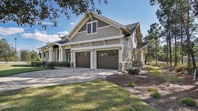 craftsman house with a garage and a front lawn