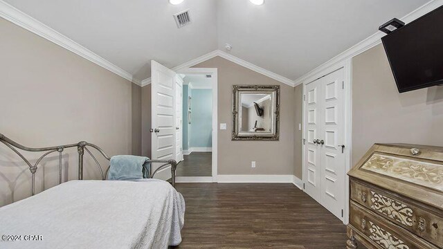 bedroom featuring crown molding, dark wood-type flooring, lofted ceiling, and a closet