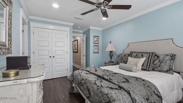 bedroom with dark wood-type flooring, a closet, ceiling fan, and crown molding