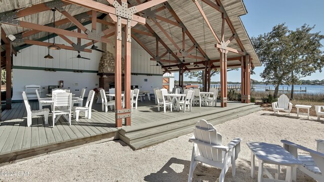 view of patio with ceiling fan and a deck with water view