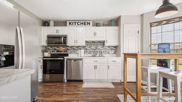 kitchen featuring dark wood-type flooring, a healthy amount of sunlight, appliances with stainless steel finishes, and white cabinets