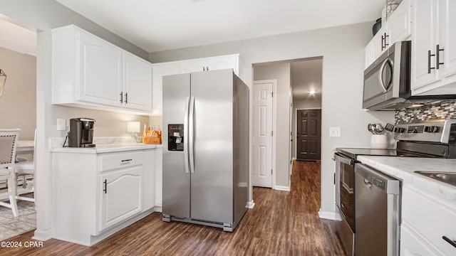 kitchen featuring appliances with stainless steel finishes, white cabinets, backsplash, and dark hardwood / wood-style floors