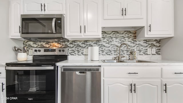 kitchen with appliances with stainless steel finishes, white cabinetry, and sink