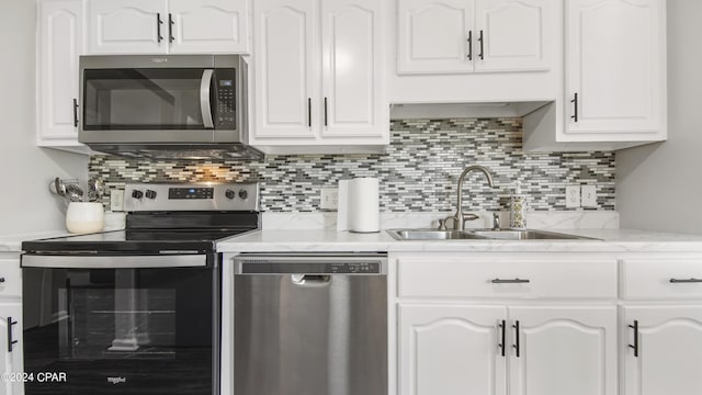 312 Lantana St, Panama City Beach, FL 32407 - kitchen featuring white cabinetry, backsplash, stainless steel appliances, and a sink