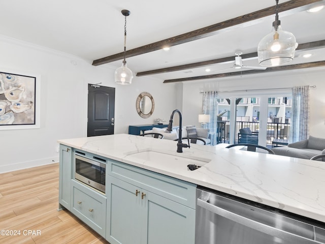 kitchen featuring appliances with stainless steel finishes, light hardwood / wood-style flooring, light stone counters, and pendant lighting