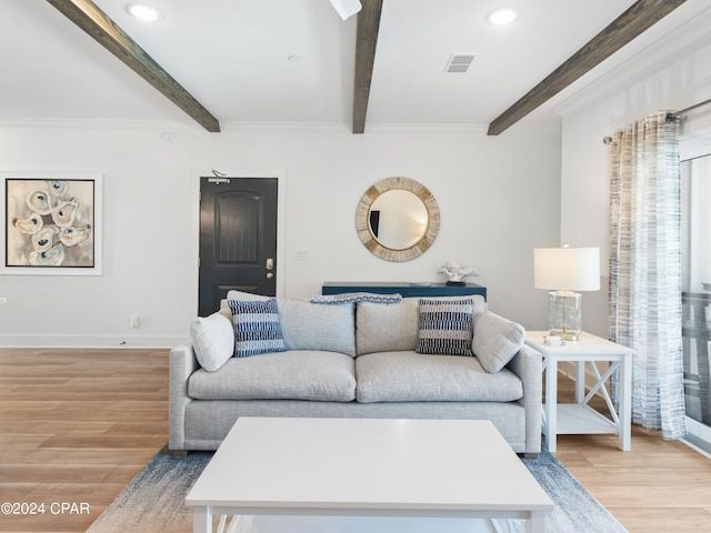 living room featuring beam ceiling, ornamental molding, and light wood-type flooring