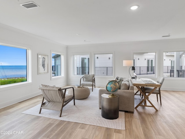 living room featuring a water view, light hardwood / wood-style floors, and crown molding