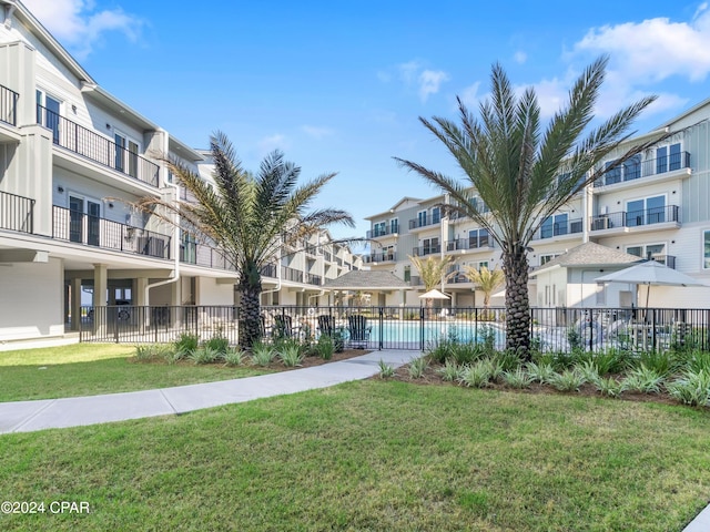 view of home's community featuring a yard and a swimming pool