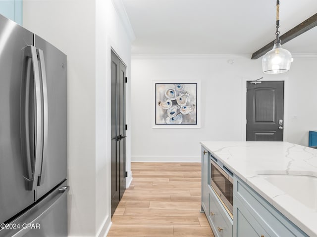 kitchen featuring ornamental molding, light stone countertops, decorative light fixtures, light wood-type flooring, and appliances with stainless steel finishes