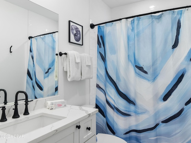 bathroom featuring vanity, curtained shower, and toilet