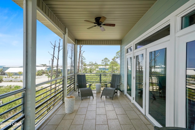 unfurnished sunroom featuring ceiling fan