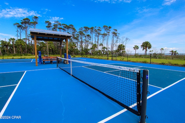 view of tennis court featuring basketball hoop