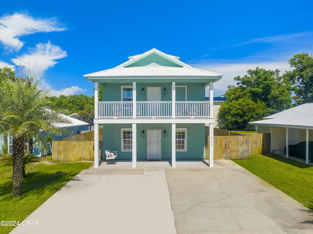 view of front of home featuring a front yard, a carport, and a balcony