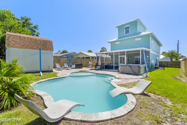 view of pool featuring a patio area, a sunroom, a lawn, a storage shed, and a hot tub