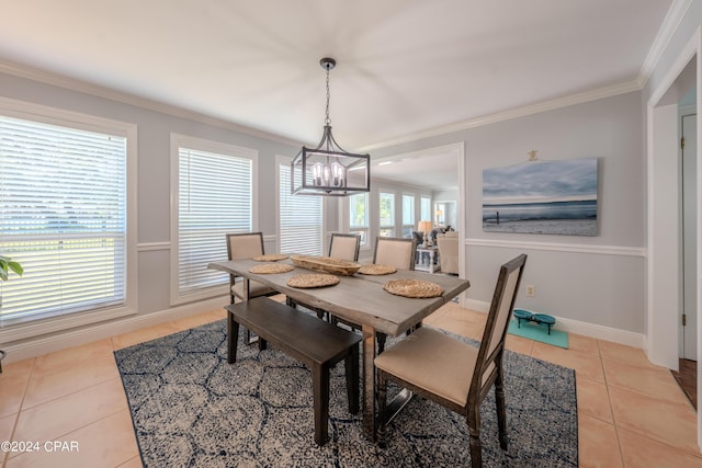 dining room with a notable chandelier, ornamental molding, and light tile patterned flooring