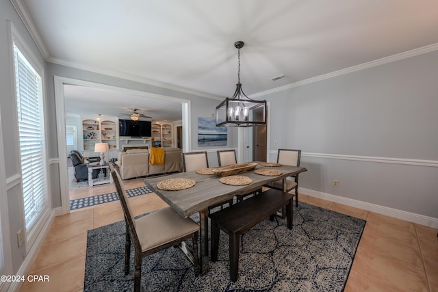 dining room featuring light tile patterned floors, a wealth of natural light, built in features, and ornamental molding