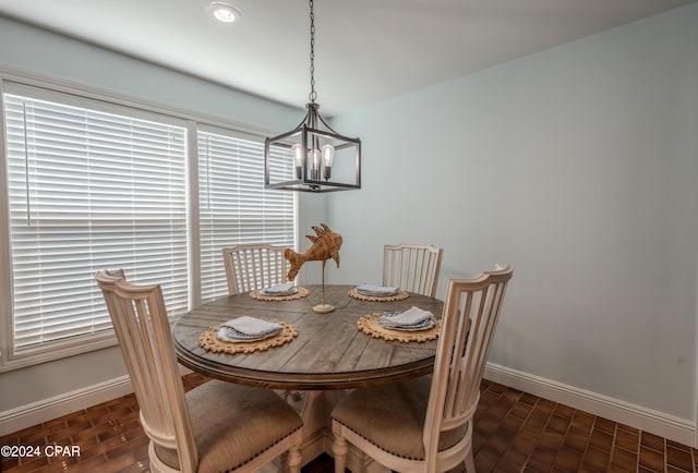 dining space with dark wood-type flooring and a chandelier