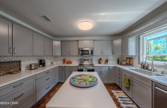 kitchen featuring sink, appliances with stainless steel finishes, gray cabinetry, and tasteful backsplash