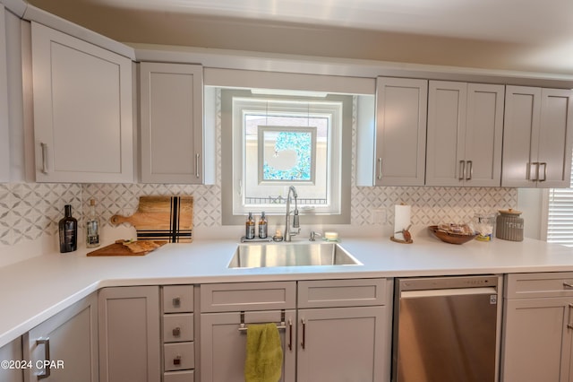 kitchen featuring gray cabinets, decorative backsplash, sink, and dishwasher