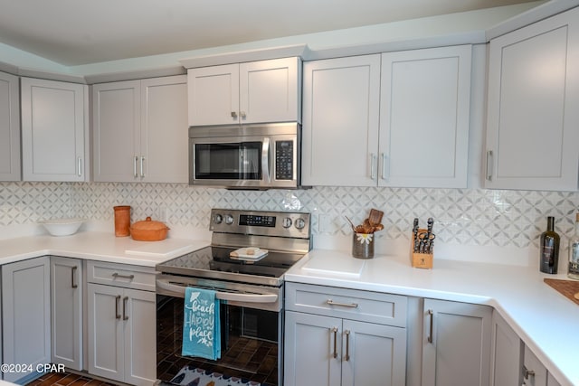 kitchen featuring appliances with stainless steel finishes, decorative backsplash, and gray cabinetry