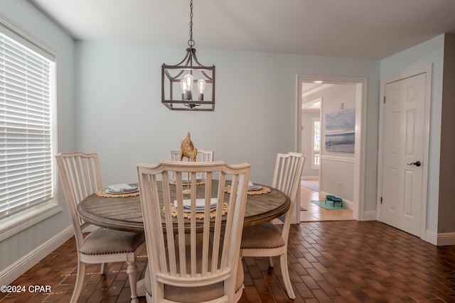 dining space with dark hardwood / wood-style flooring and a notable chandelier