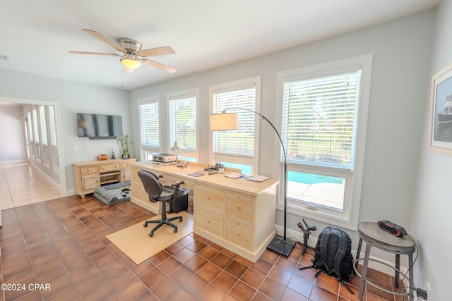 tiled home office featuring ceiling fan