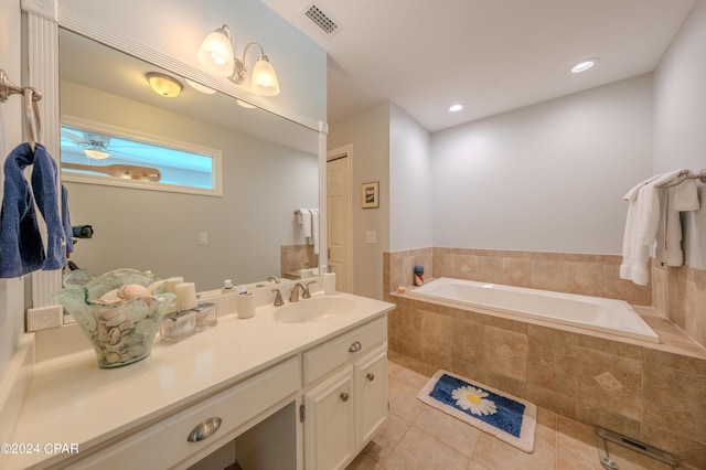 bathroom featuring vanity, tile patterned flooring, and tiled tub