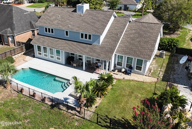 rear view of property featuring central AC, a lawn, a fenced in pool, and a patio area